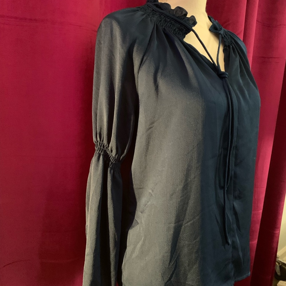 Size XS feels like a medium. Navy shiny blue. Hardly worn, top for work.